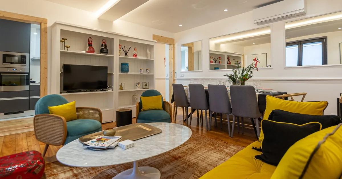 Sala de estar ampla com sofá amarelo, poltronas azuis e mesa de jantar em madeira com decoração acolhedora de inverno