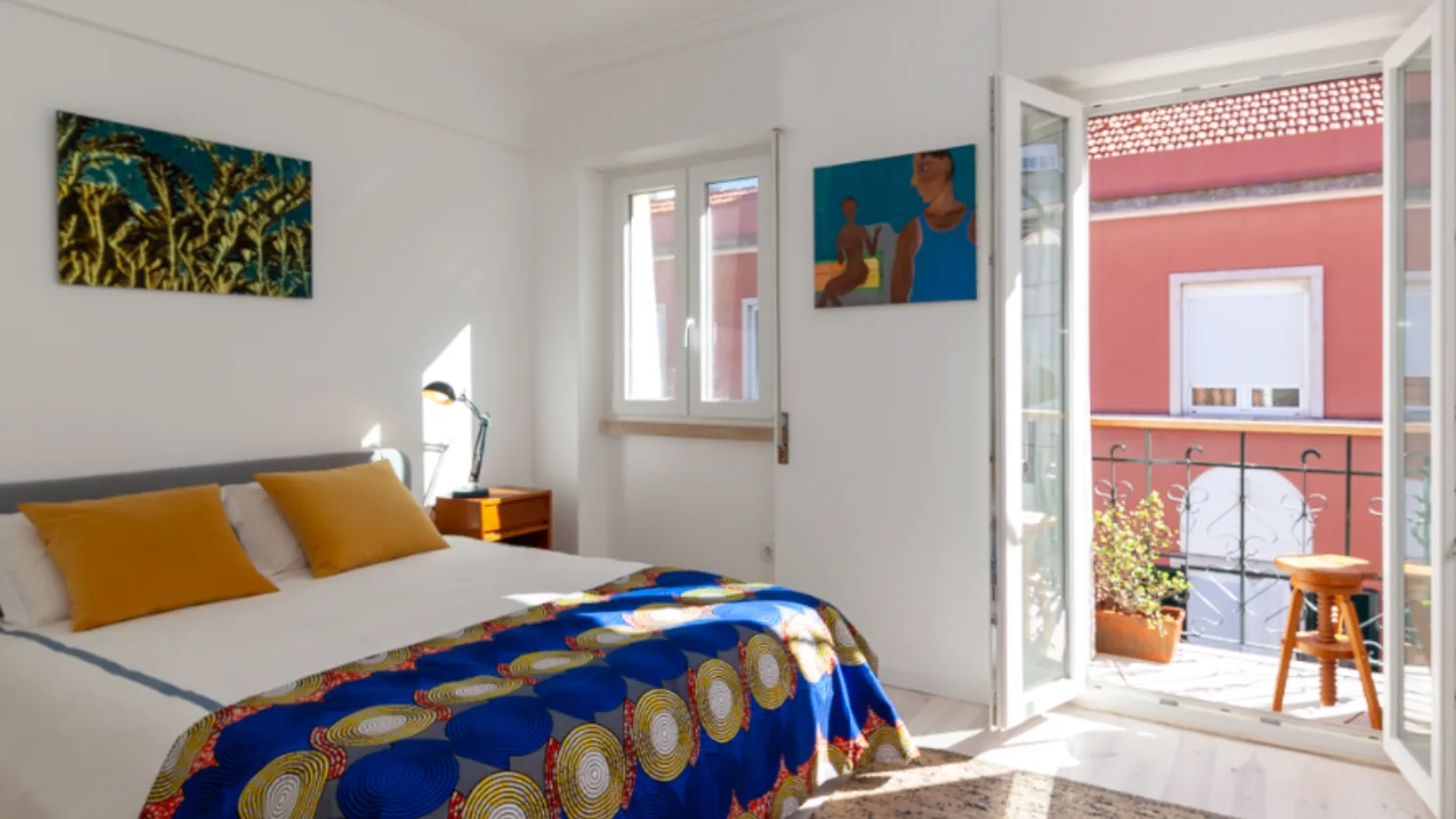 Quarto reabilitado com porta aberta para uma varanda em Lisboa